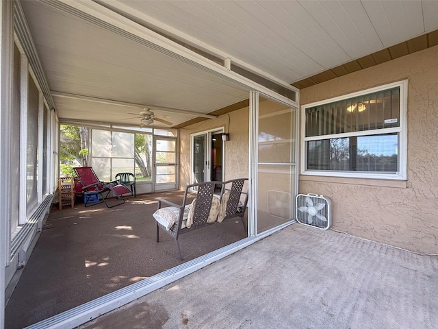 unfurnished sunroom with ceiling fan