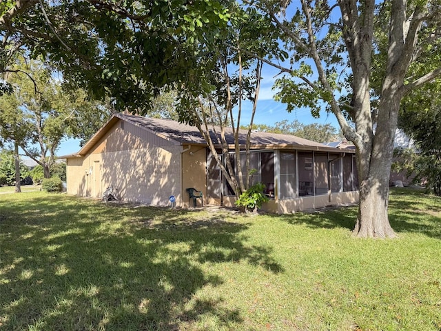 back of property with a sunroom and a lawn