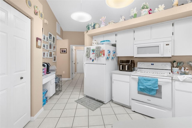 kitchen with lofted ceiling, white cabinets, white appliances, and light tile patterned flooring