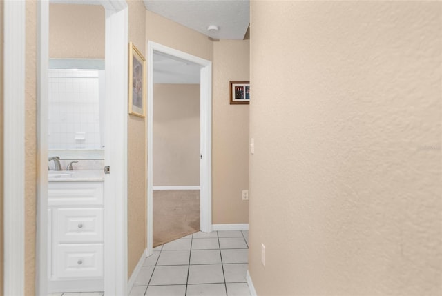 corridor with sink and light tile patterned floors