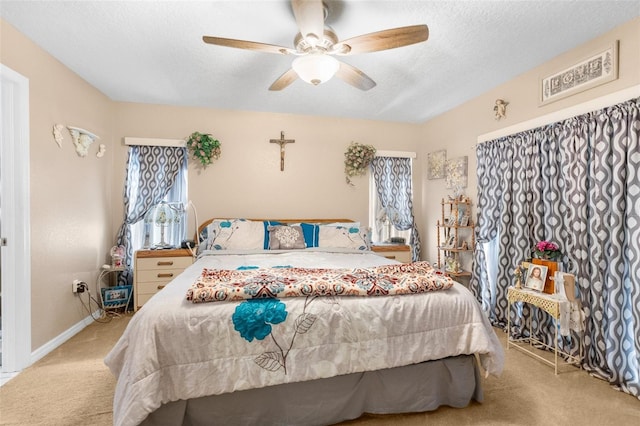 bedroom with light carpet, a textured ceiling, and ceiling fan