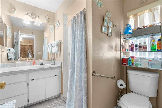 bathroom featuring toilet, vanity, a shower with shower curtain, and tile patterned flooring