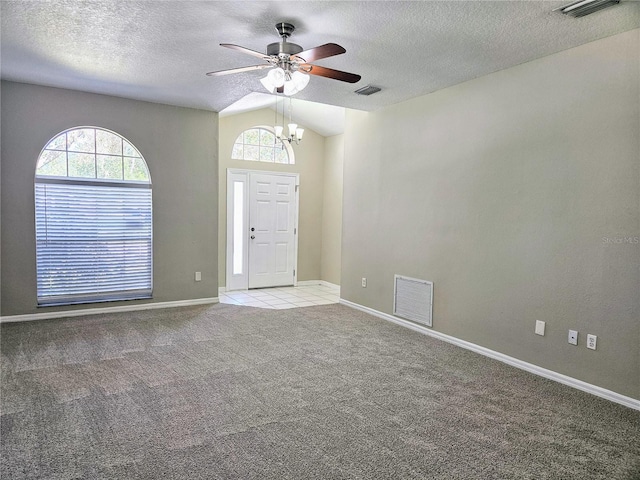 foyer featuring light colored carpet, a wealth of natural light, and vaulted ceiling