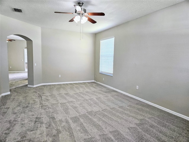 carpeted spare room with ceiling fan and a textured ceiling