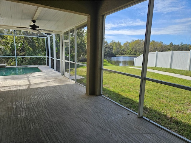 unfurnished sunroom with a water view and ceiling fan