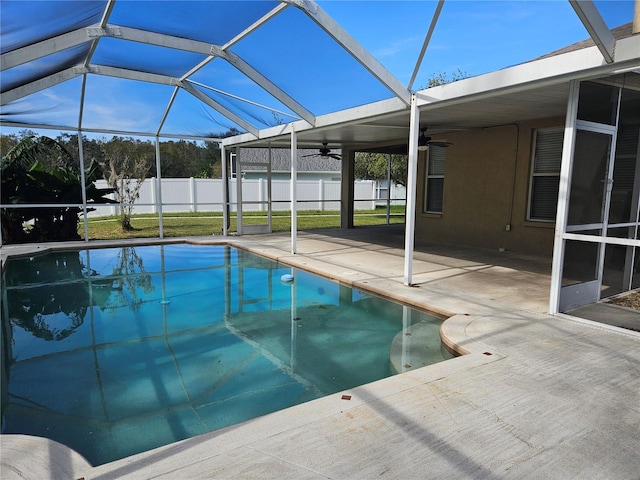 view of swimming pool with ceiling fan, a patio area, and glass enclosure