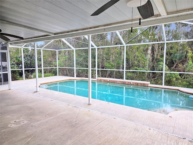 view of pool with a patio area, ceiling fan, and glass enclosure