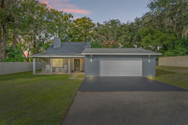 view of front of home with a garage and a lawn