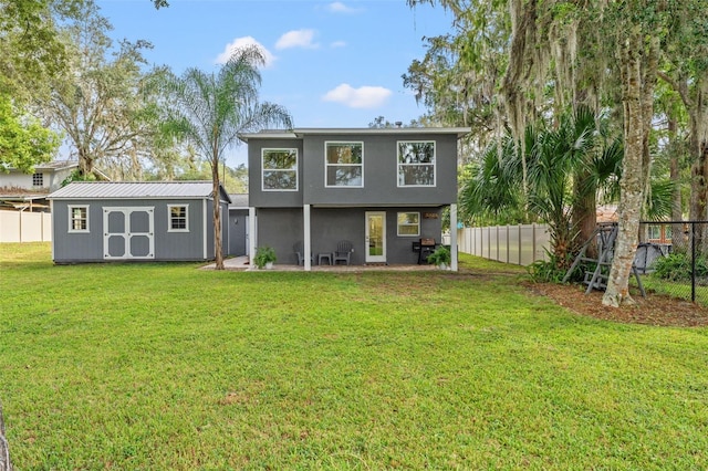 back of house with a storage shed, a lawn, and a patio area