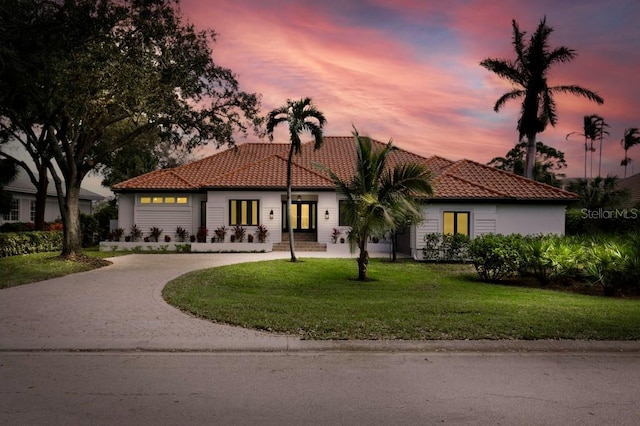 mediterranean / spanish home featuring a lawn