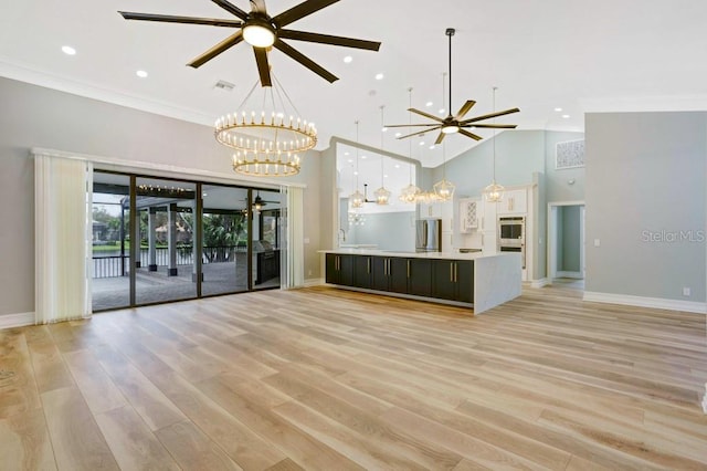 unfurnished living room featuring ornamental molding, high vaulted ceiling, light hardwood / wood-style floors, and ceiling fan with notable chandelier