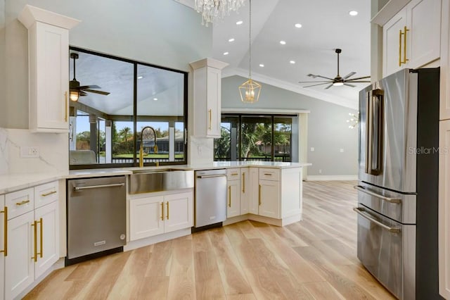 kitchen featuring white cabinetry, appliances with stainless steel finishes, lofted ceiling, and ornamental molding