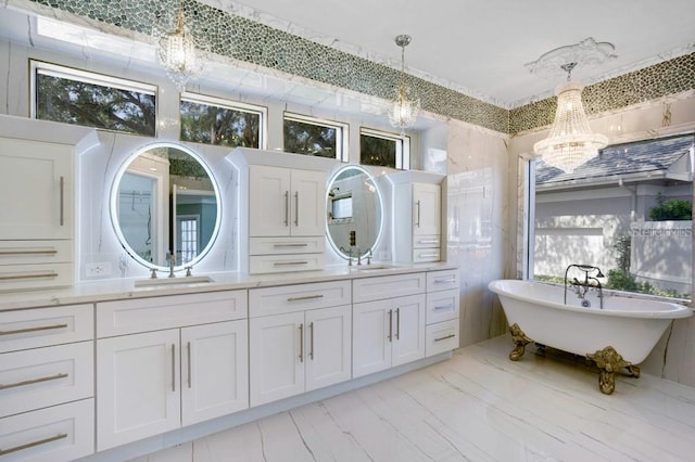 bathroom with a bathtub, vanity, and a notable chandelier