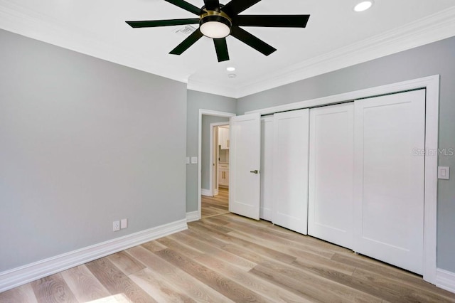 unfurnished bedroom featuring a closet, light hardwood / wood-style floors, ceiling fan, and crown molding