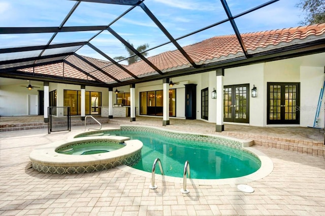 view of swimming pool featuring glass enclosure, a patio area, ceiling fan, and an in ground hot tub