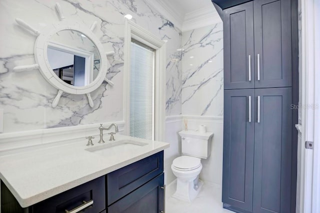 bathroom featuring vanity, toilet, and ornamental molding