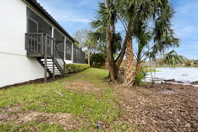 view of yard featuring glass enclosure and a water view