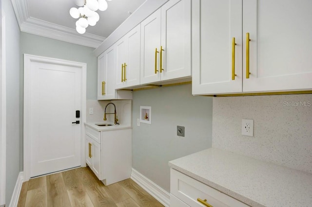 laundry area featuring sink, ornamental molding, electric dryer hookup, hookup for a washing machine, and light wood-type flooring