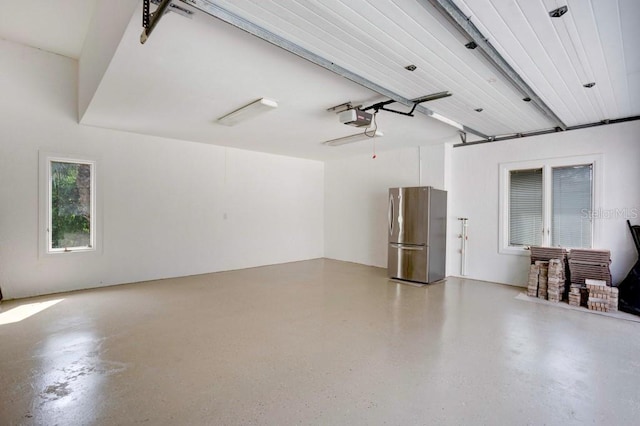 garage featuring a garage door opener and stainless steel fridge