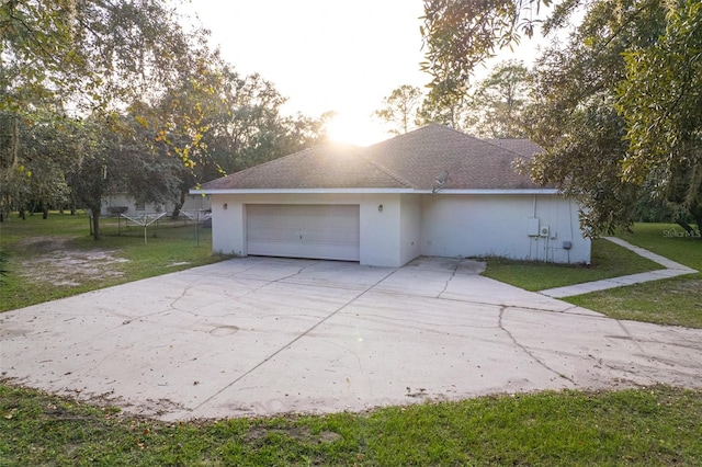 view of side of property featuring a garage and a lawn