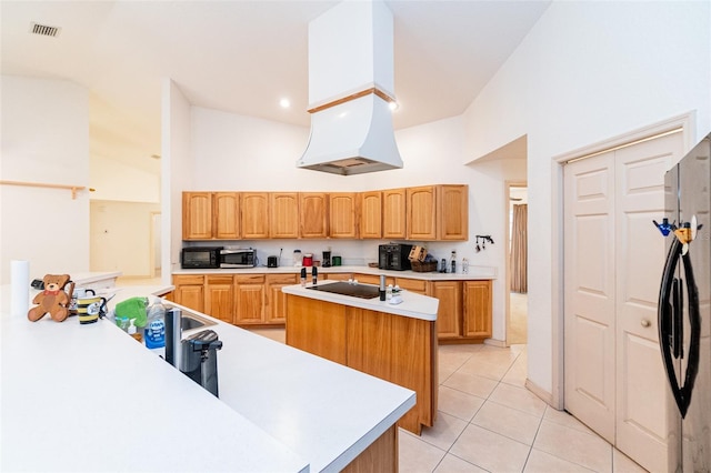 kitchen with light tile patterned floors, high vaulted ceiling, black appliances, and a center island