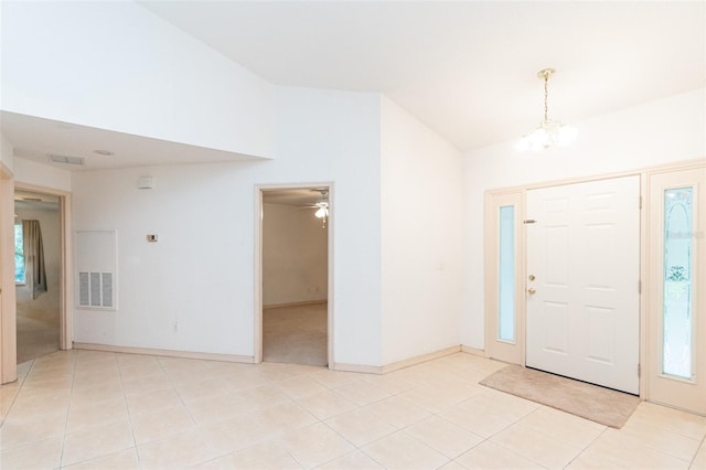 tiled foyer with a notable chandelier, a healthy amount of sunlight, and lofted ceiling