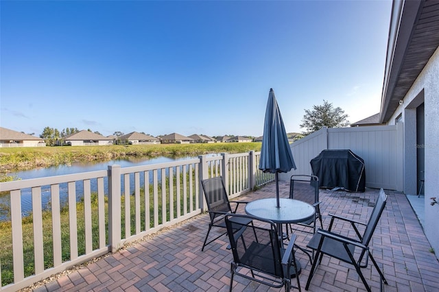 view of patio / terrace featuring a water view and grilling area