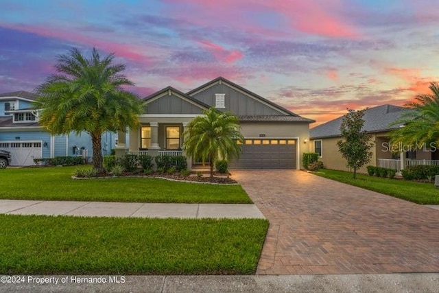 view of front of home with a yard and a garage