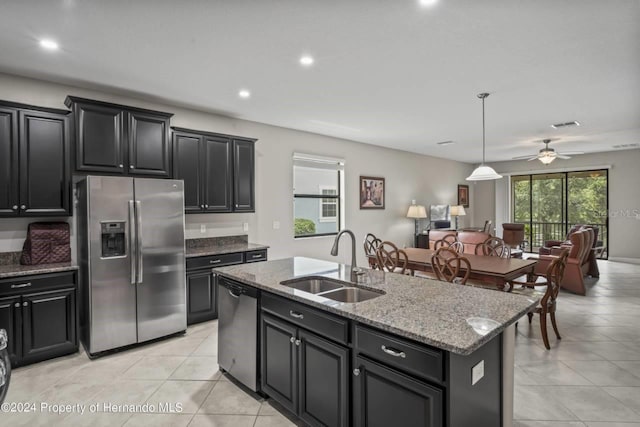 kitchen with pendant lighting, a kitchen island with sink, sink, ceiling fan, and stainless steel appliances