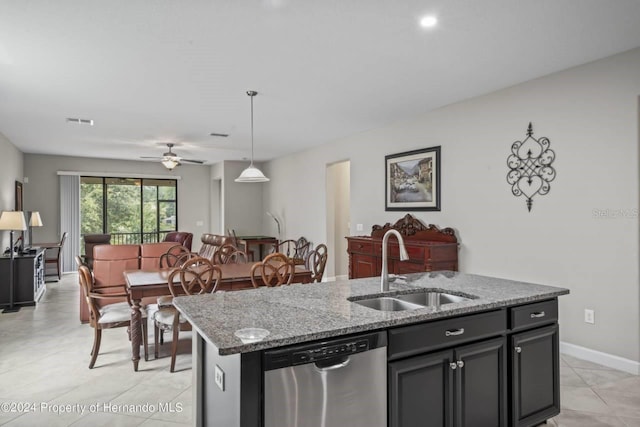 kitchen with stainless steel dishwasher, ceiling fan, sink, pendant lighting, and an island with sink