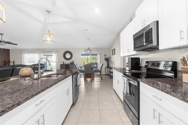 kitchen with dark stone counters, sink, white cabinets, pendant lighting, and appliances with stainless steel finishes