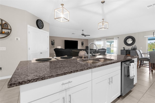 kitchen featuring sink, dishwasher, an island with sink, and hanging light fixtures