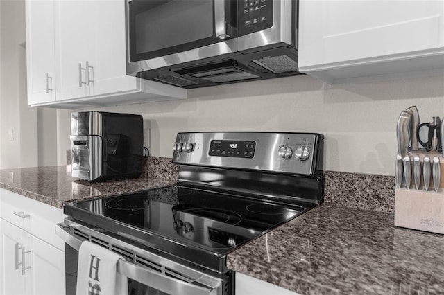 kitchen featuring appliances with stainless steel finishes, white cabinets, and dark stone countertops