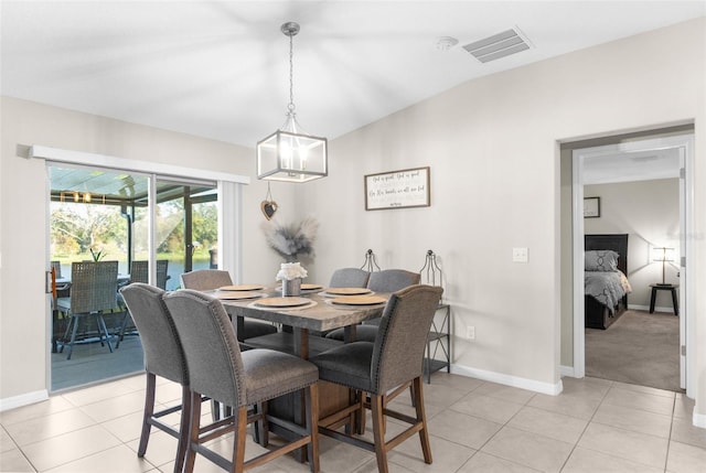 dining room featuring a chandelier, vaulted ceiling, and light tile patterned floors