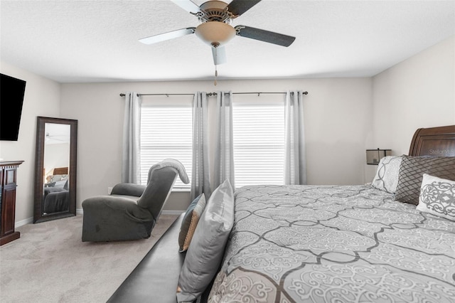 bedroom featuring a textured ceiling, light colored carpet, and ceiling fan