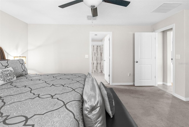 bedroom featuring ensuite bath, light carpet, and ceiling fan