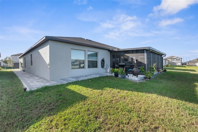 back of property with a yard and a sunroom