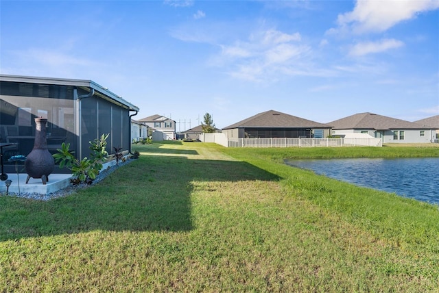 view of yard featuring a water view and a sunroom