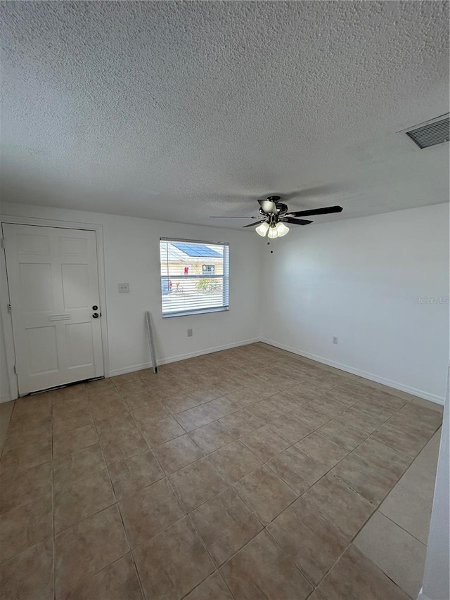 tiled empty room with a textured ceiling and ceiling fan