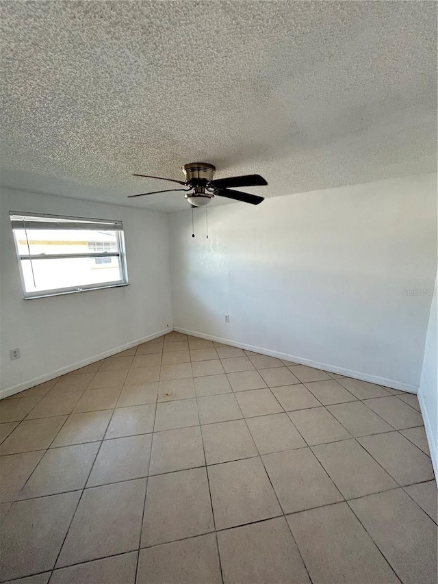 empty room with ceiling fan and light tile patterned flooring