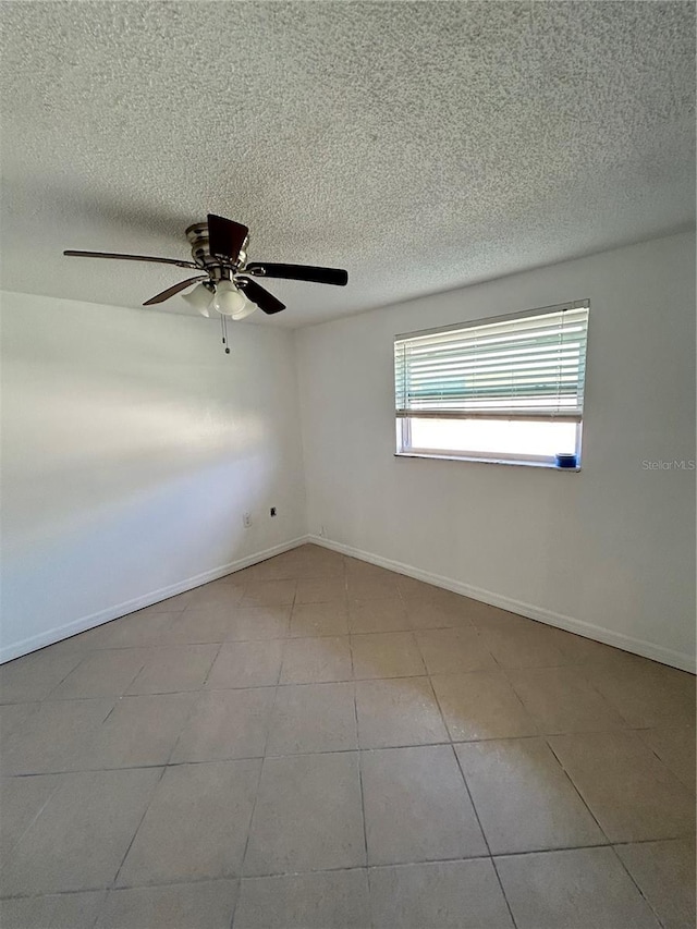 spare room featuring ceiling fan and light tile patterned floors