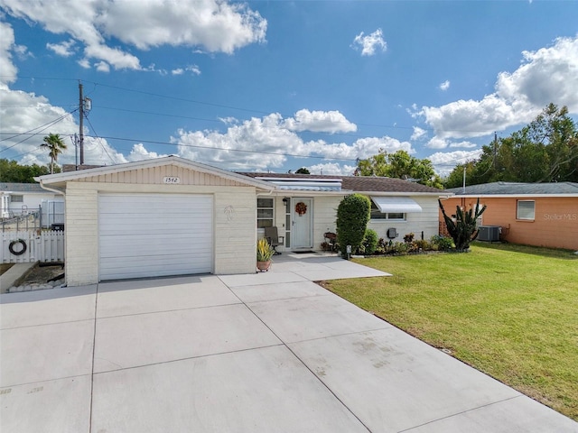 ranch-style house with solar panels, a garage, central AC unit, and a front yard