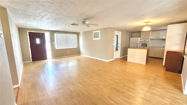 unfurnished living room featuring ceiling fan, light hardwood / wood-style floors, and a textured ceiling