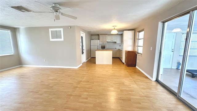 kitchen featuring white appliances, light hardwood / wood-style flooring, ceiling fan, a textured ceiling, and decorative backsplash