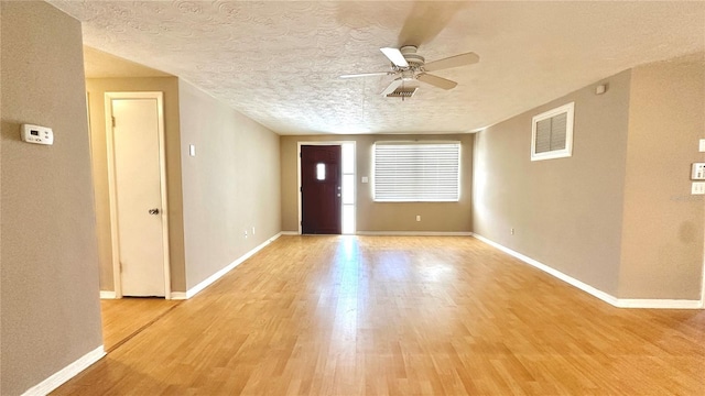 entryway with ceiling fan, light hardwood / wood-style flooring, and a textured ceiling