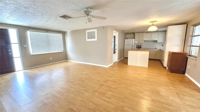 unfurnished living room featuring ceiling fan, a textured ceiling, and light wood-type flooring