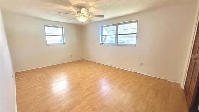 empty room featuring ceiling fan, light hardwood / wood-style floors, and a textured ceiling