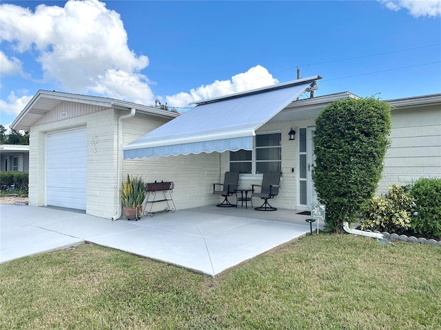 back of house with a garage and a yard