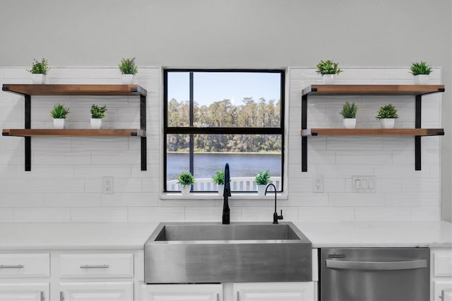 kitchen featuring sink, dishwasher, and white cabinets