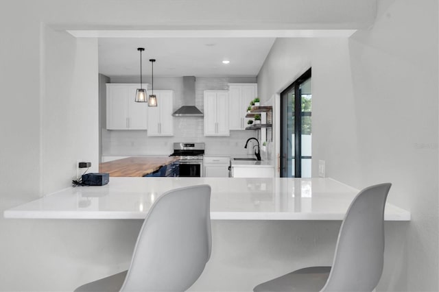 12135 Crestridge Loop, Trinity, FL 34655 - kitchen with stainless steel range, a sink, wall chimney exhaust hood, white cabinetry, and decorative backsplash